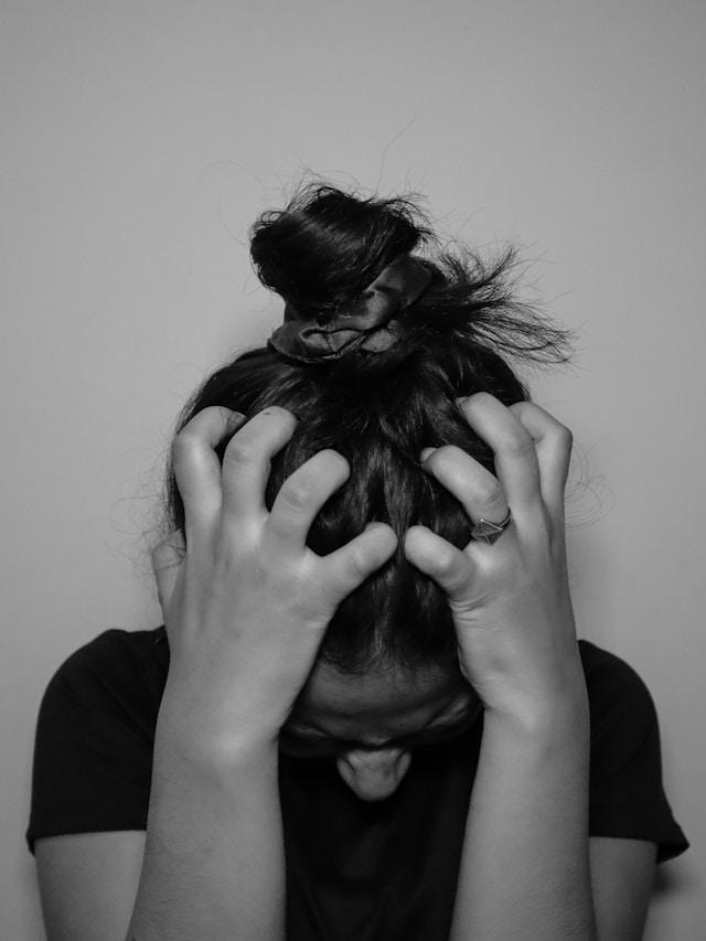 a stressed woman holding her head